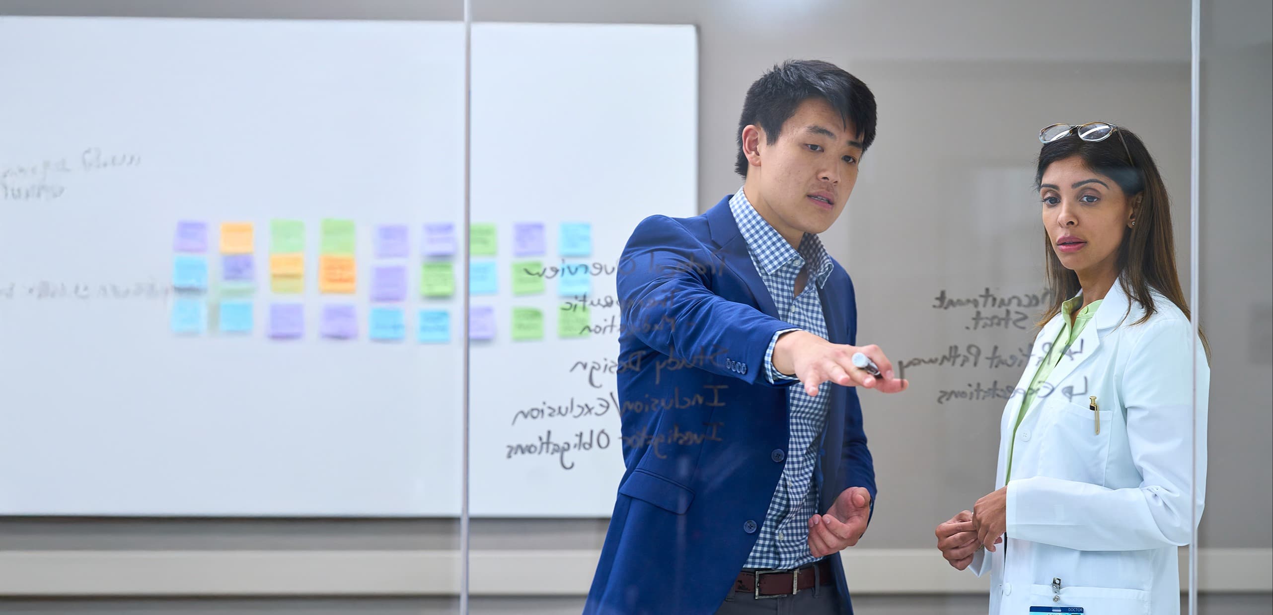 man and woman looking at whiteboard