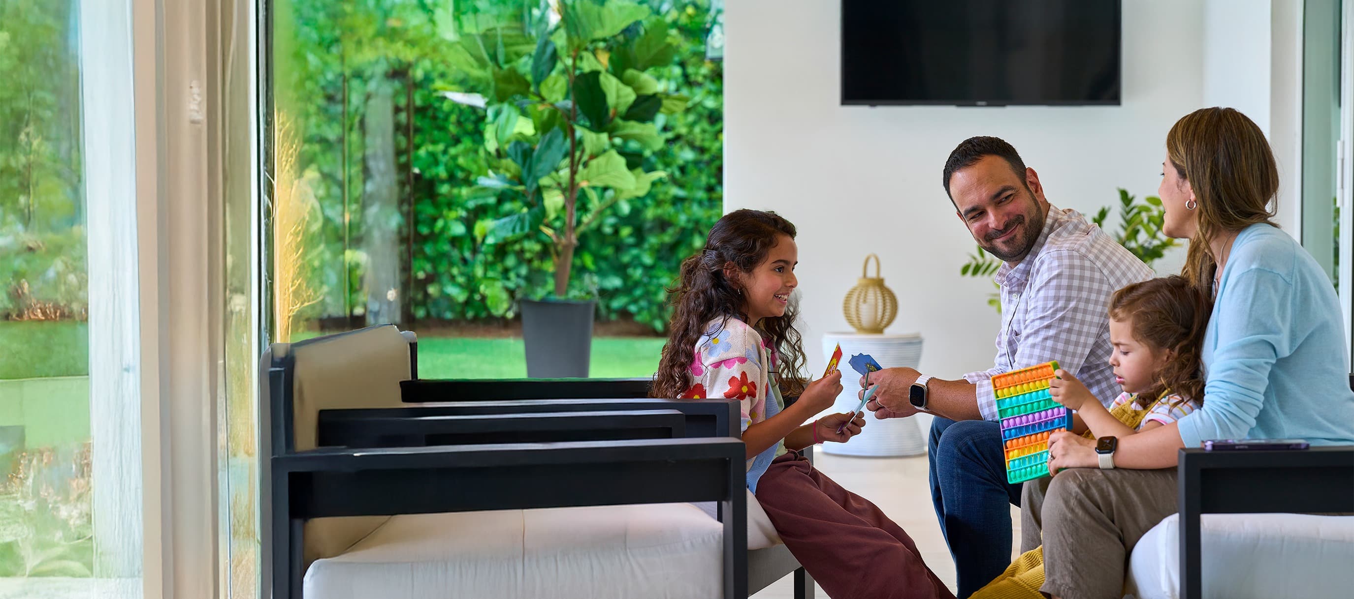 family in living room smiling and playing with kids