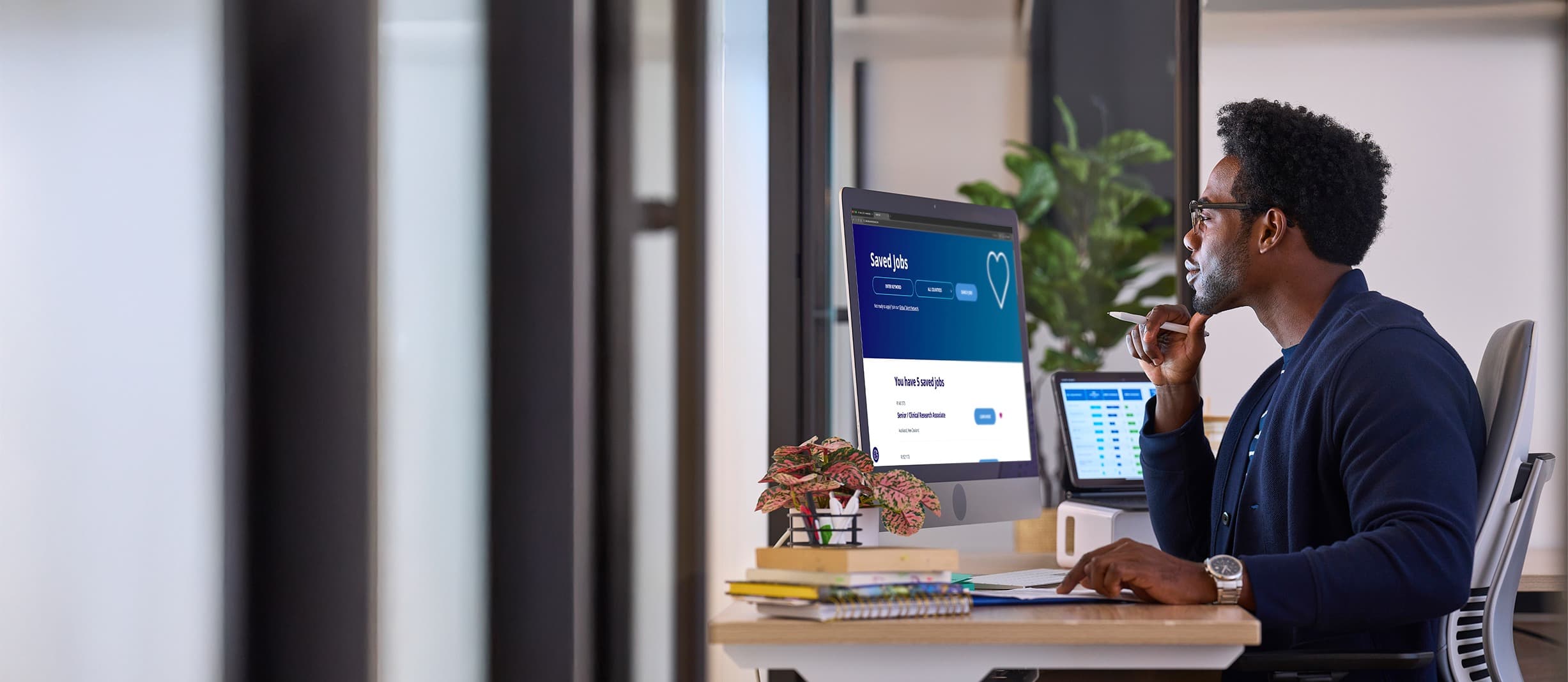man looking at computer screen with saved jobs page