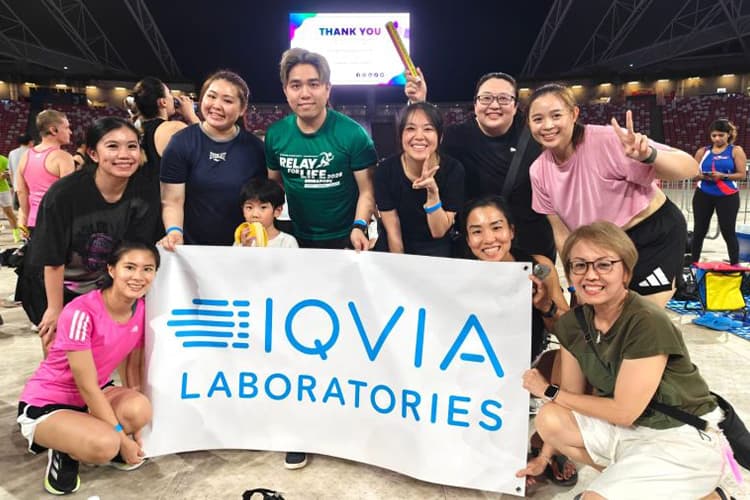 IQVIA Laboratories employees posing together with sign at relay for life